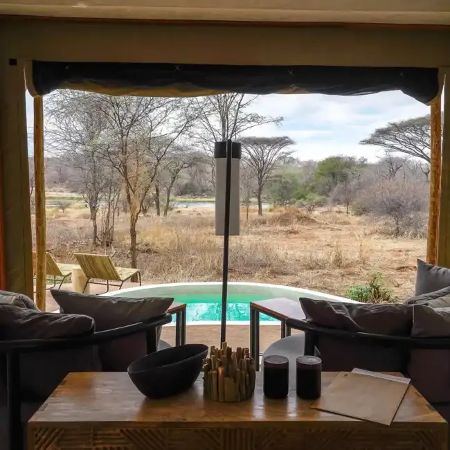 Tent lounge with private plunge pool overlooking a river and bushland in the Serengeti, Tanzania